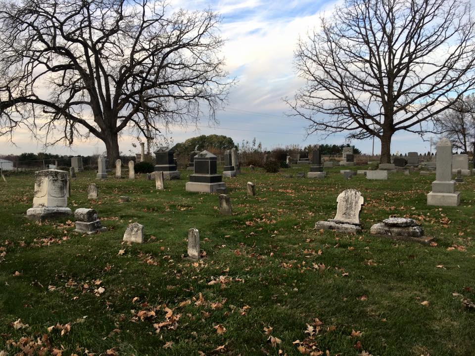 Scenic view of a historic cemetery with celtic cross silhouette and natural surroundings